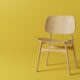 a wooden chair on a yellow background