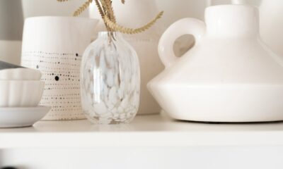 a white shelf topped with lots of white vases