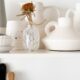 a white shelf topped with lots of white vases